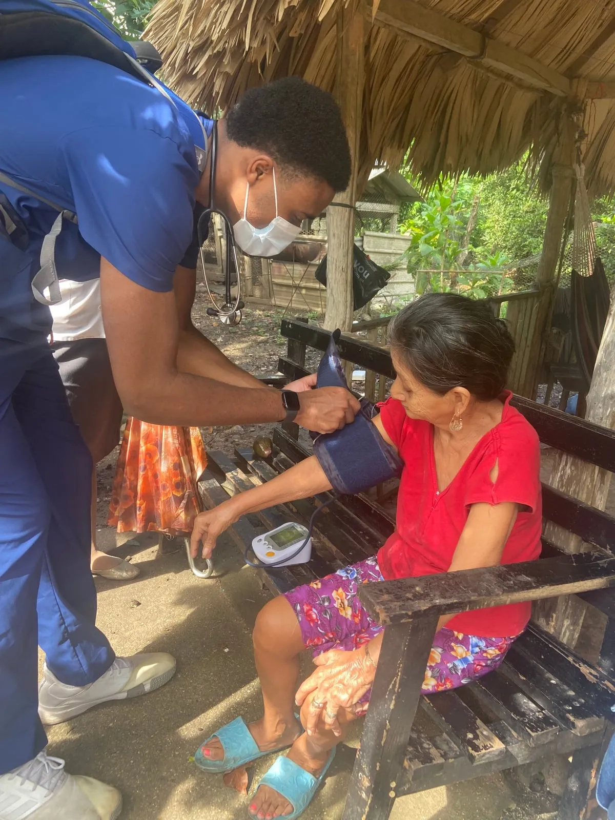 Nursing students examining a child in a Belizean home