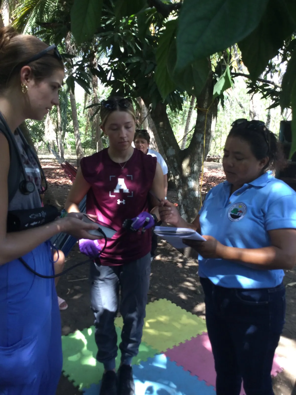 Students and a community health worker on a home visit in Belize