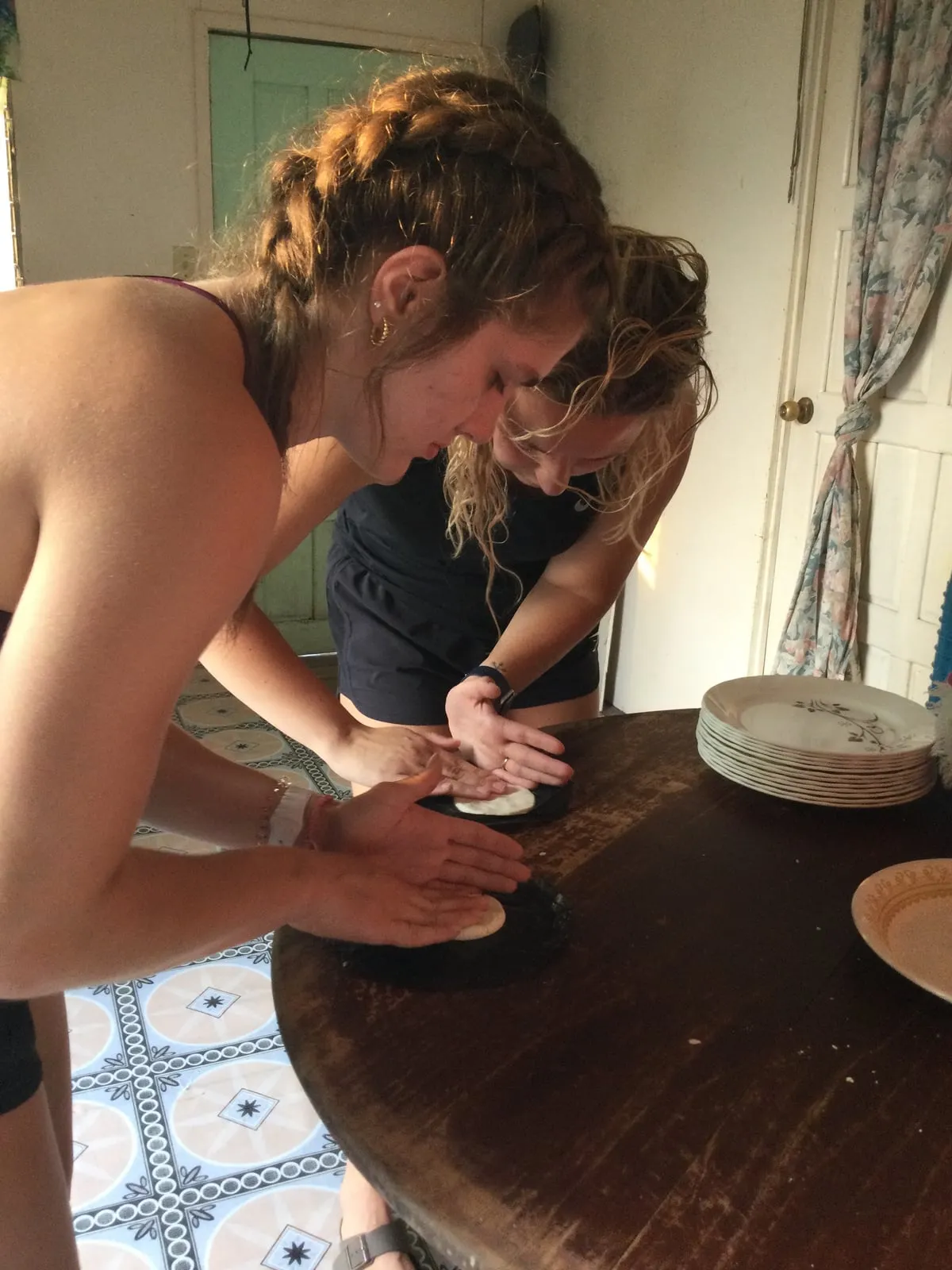 Students learning to make tortillas in a Belizean home