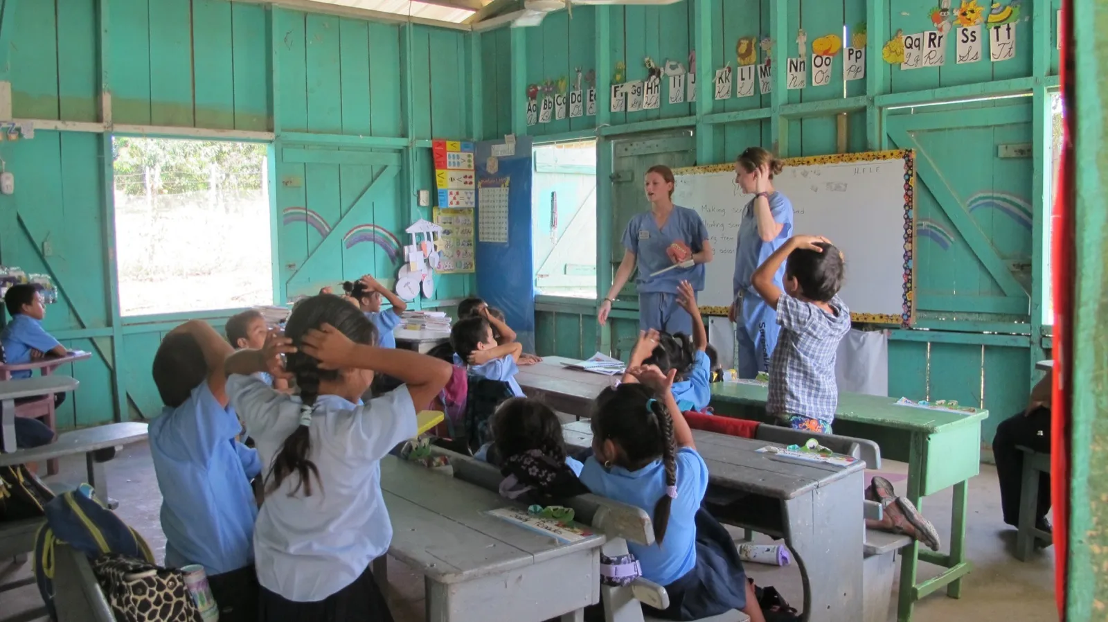 Nursing students leading a health lesson for children in a Belize classroom
