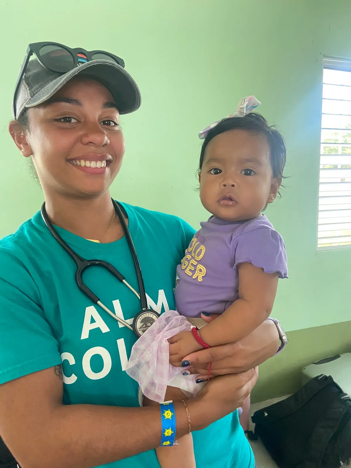 Nursing student holding a baby at a community clinic in Belize