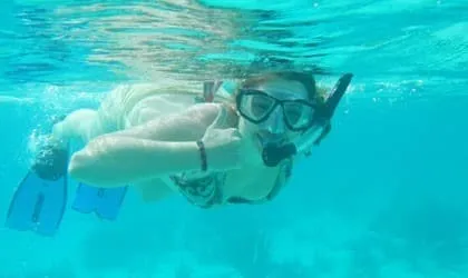 Student snorkeling in clear tropical water