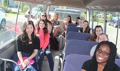 Smiling students on the program bus