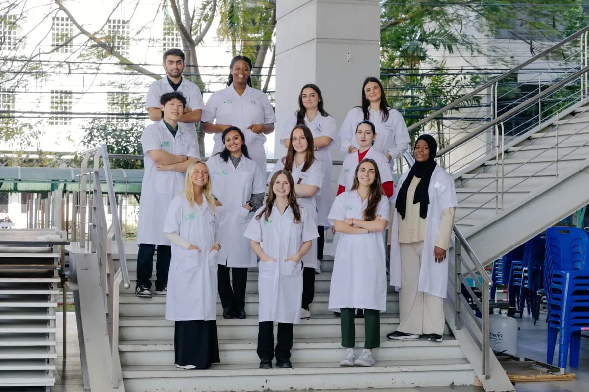 Students in white coats with the Chiang Mai team