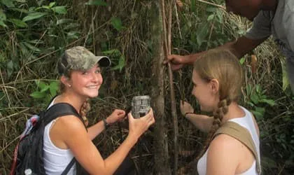Students setting up a wildlife camera trap in the forest
